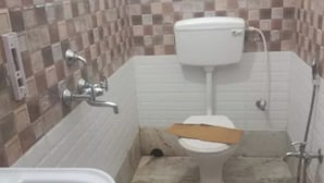 Un baño con inodoro, lavabo y zona de ducha.