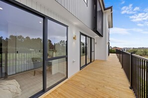Ein modernes Gebäude mit großen Glasfenstern und einer Holzterrasse.
