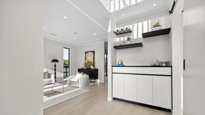Ein modernes Interieur mit Küchenbereich, ausgestattet mit weißen Schränken, einer schwarzen Arbeitsplatte und Dekorationselementen.
