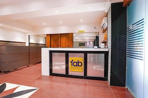 Una zona de recepció amb mostrador, armaris de fusta i un cartell de 'fab hotels'.