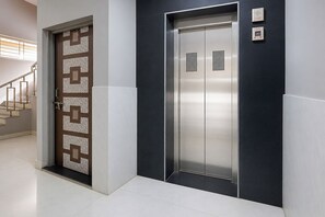 Un moderno ascensor con detalles metálicos y una puerta con diseño.