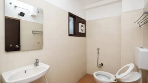A small bathroom with a sink, toilet, and a mirror. - Fabhotel Regal I (Hyderabad)