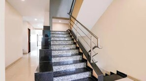 Una escalera con barandilla y cerramiento de vidrio en el lado izquierdo.