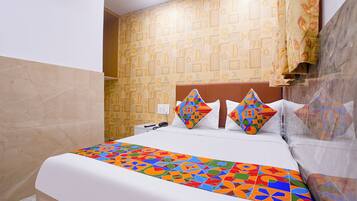 Una habitación de hotel con una cama, una pared de madera con diseños alfabéticos y una colcha estampada.