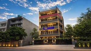 A multi-story building with a prominent 'fabHOTELS' sign, featuring balconies and a gated entrance. - Fabhotel Golden Moment (Gurugram)