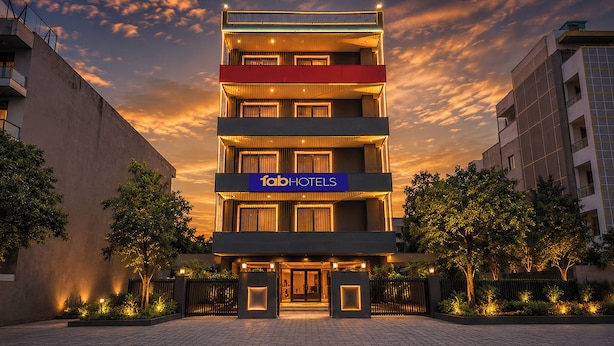 A multi-story hotel with a prominent 'fabHOTELS' sign, a gated entrance, and a landscaped front yard. - Fabhotel Golden Moment (Gurugram)