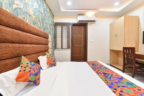 A hotel room with a bed, a desk, and a wardrobe. - FabHotel Amrit Inn (Indore)