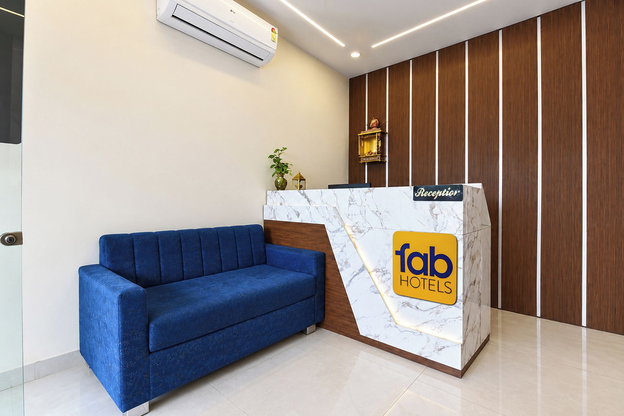 A reception desk with a marble top and a blue sofa.
