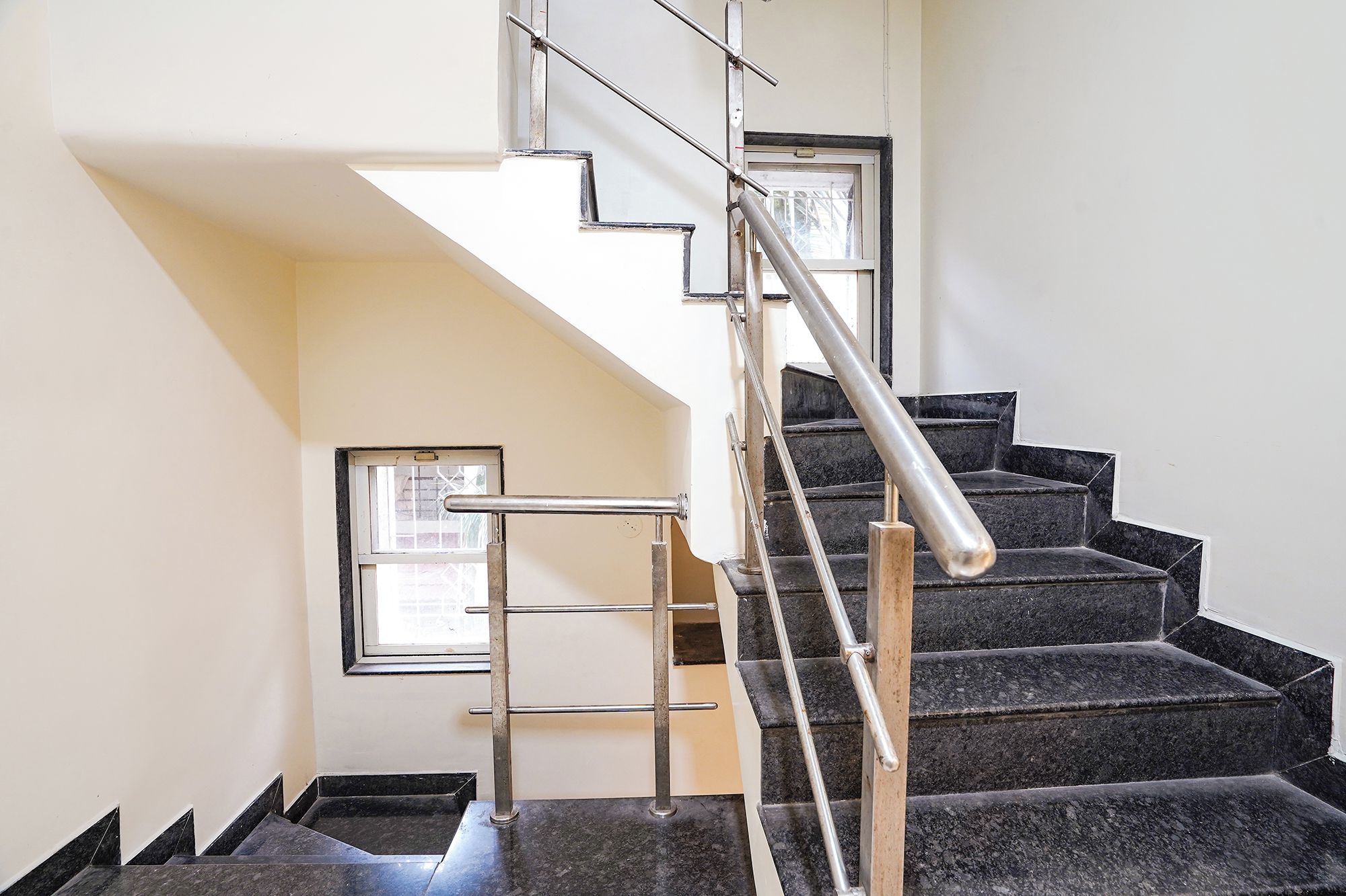 A staircase with metal handrails and black steps.