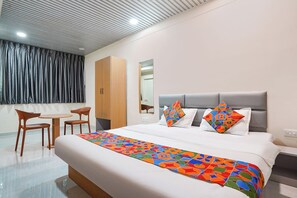 Une chambre d’hôtel moderne avec un grand lit, un bureau et une chaise.