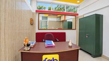 A reception desk with a 'fab hotels' sign, a mirror above it, and a green storage cabinet to the right.