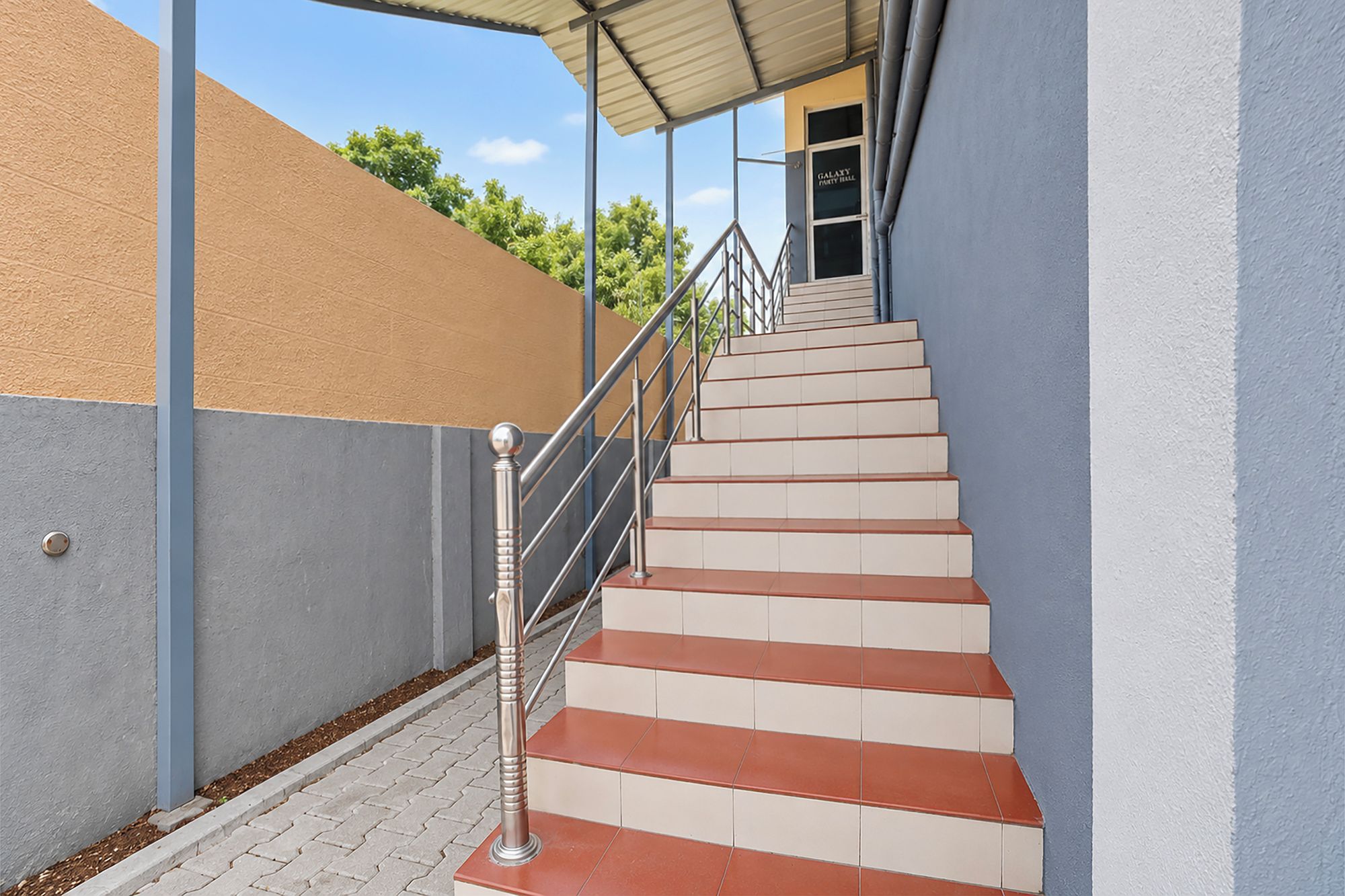Eine Treppe mit Metallgeländern, die zu einem Hauseingang führt.