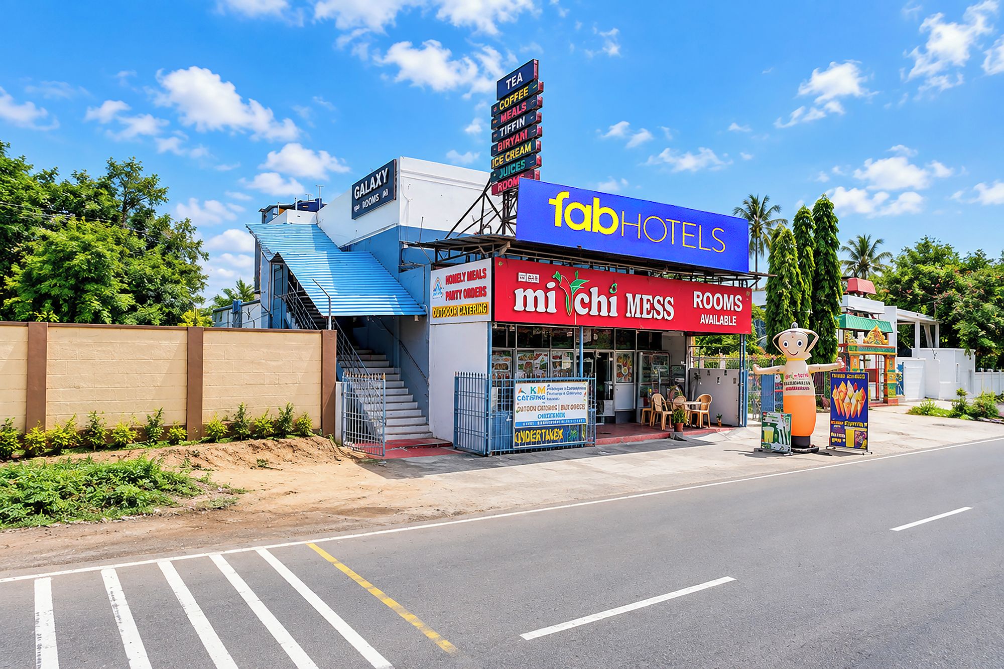 A hotel with a signboard for 'Tab Hotels' and 'Michi Mess' offering rooms and food services.