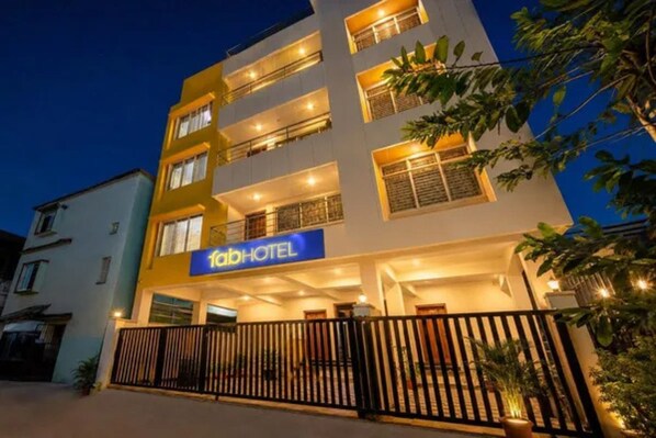A multi-story hotel with a prominent sign, balconies, and a gated entrance.