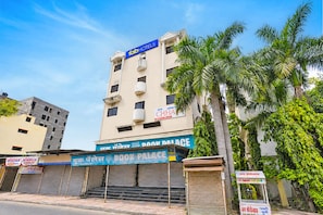A multi-story building with a sign for 'Fab Hotels' and a 'Book Palace' sign below. - Fabhotel Chaya (Chhatrapati Sambhajinagar)