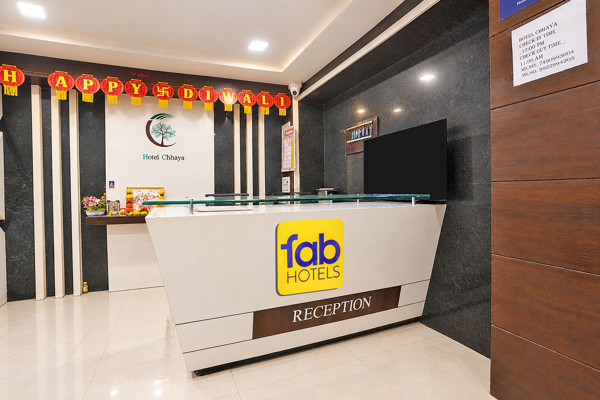 Zona de recepción de un hotel con diseño moderno, un mostrador de recepción y un letrero que dice 'fab hotels'.