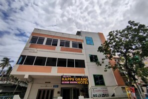A multi-story building with a sign for the Happy Grand Hotel. - Fabhotel Happy Grand (Vijayawada)