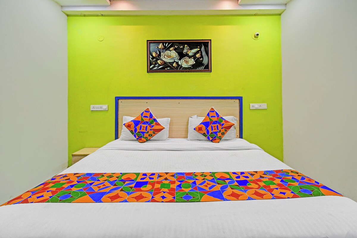 A bed with a colorful geometric-patterned bedspread and two pillows with similar designs.