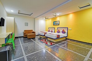 A hotel room with a bed, a sofa, a desk, and a chair. - FabHotel Living Tree Suites (Hyderabad)