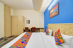 Une chambre d’hôtel avec un lit, un bureau et des chaises.