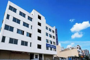 Un edificio de hotel de varios pisos con un letrero llamativo que dice 'Living Tree Suites'.