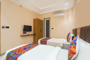 A hotel room with two beds, a TV, and an air conditioning unit. - FabHotel Shri Hari Villa (Varanasi)