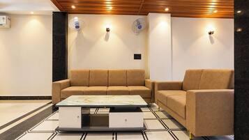 A modern living room with a sofa, a coffee table, and wall-mounted fans.
