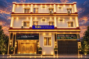Un hotel amb un cartell que diu 'fabHOTELS' i 'HABITACIONS DE LUXE GRAND SRY HOTEL', amb serveis com aire condicionat, Wi-Fi gratuït, aparcament i servei 24 hores.