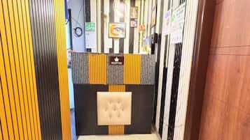 Un área de recepción con mostrador, un reloj y obras de arte enmarcadas en la pared.