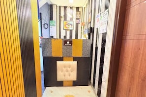 Un área de recepción con mostrador, un reloj y obras de arte enmarcadas en la pared.