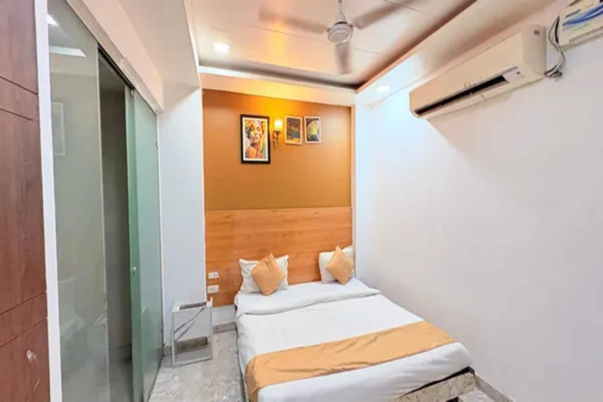 Un dormitorio con cama, cabecero de madera y aire acondicionado de pared.