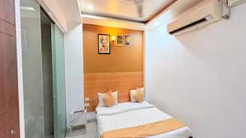 Un dormitorio con cama, cabecero de madera y aire acondicionado de pared.