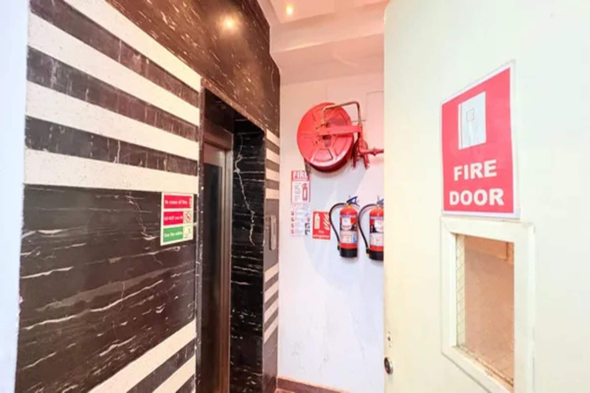 Un pasillo con un extintor montado en la pared y un letrero de puerta contra incendios.