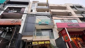 A multi-story building with various commercial establishments including a hotel named 'HOTEL GRAND VISTA' and a store named 'GREENWAYS'. - Fabhotel Grand Vista (New Delhi)