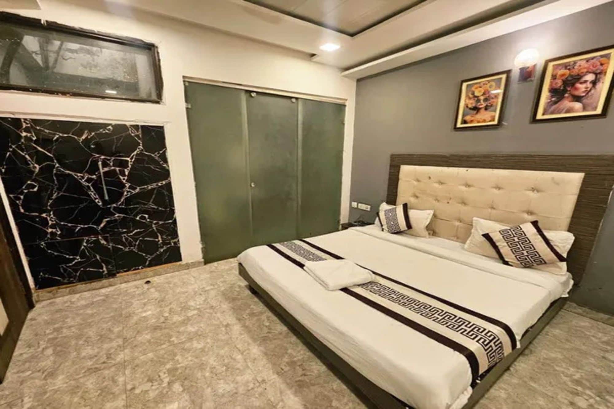 Une chambre à coucher avec un lit, une armoire et un mur en marbre.