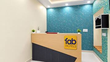 Un mostrador de recepción de hotel con diseño moderno, un logotipo y una planta en maceta.