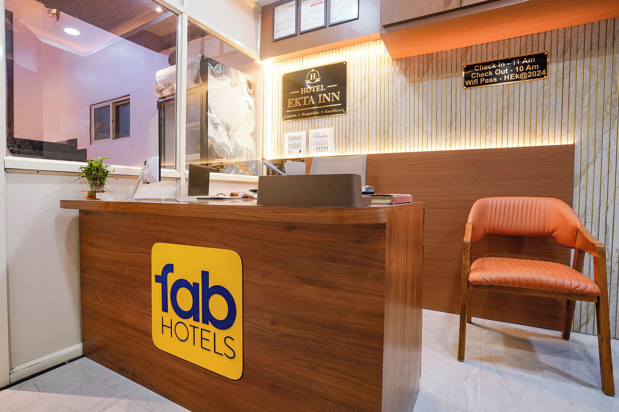 A hotel reception desk with a sign for 'fab hotels' and a check-in/out sign.