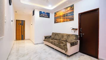 A hallway with a sofa, a door, and a wall-mounted painting.