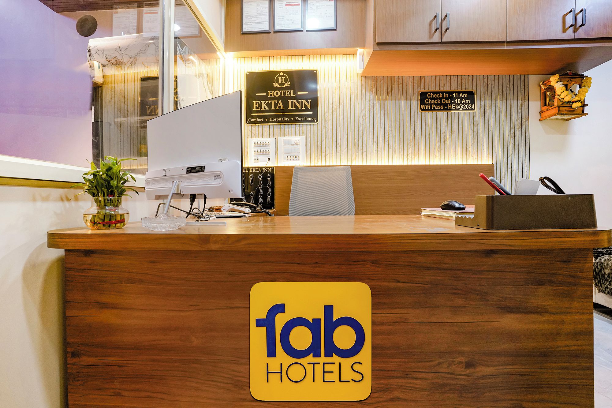 A hotel reception desk with a sign for 'Hotel Ekta Inn' and a 'fab hotels' logo.