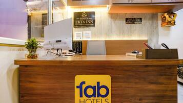 A hotel reception desk with a sign for 'Hotel Ekta Inn' and a 'fab hotels' logo.