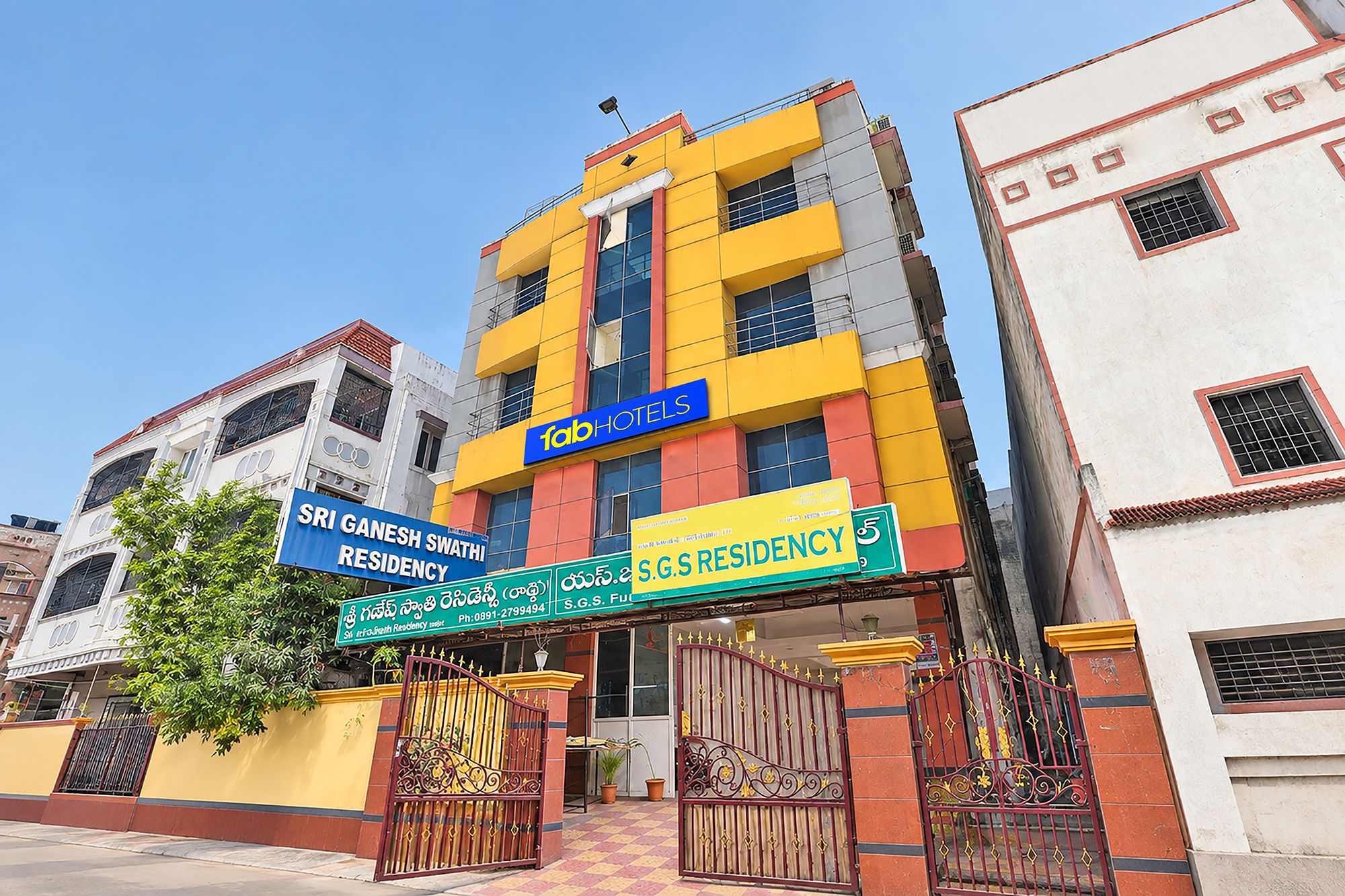 A multi-story building with signage for 'Sri Ganesh Swathi Residency' and 'Fab Hotels.'