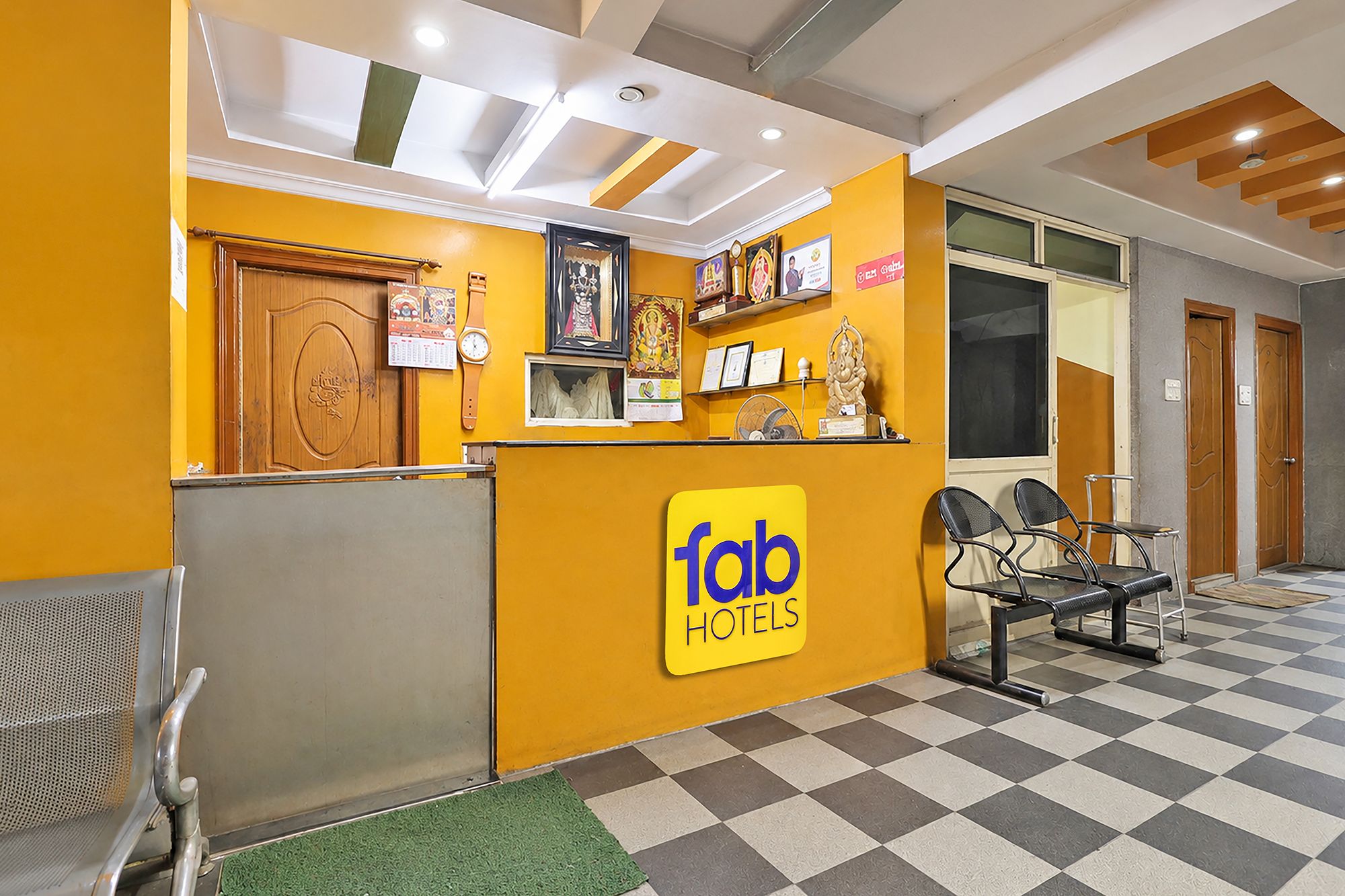 A hotel reception area with a check-in counter, seating, and a check-in desk.