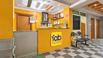 A hotel reception area with a check-in counter, seating, and a check-in desk.