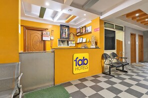 A hotel reception area with a check-in counter, seating, and a check-in desk. - FabHotel Sgs Residency (Visakhapatnam)