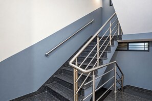 A modern staircase with metal handrails and dark granite steps. - FabHotel Shivom (Indore)
