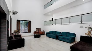 Un salón amplio con un gran ventanal, un conjunto de sofás, una mesa de centro y una chimenea.