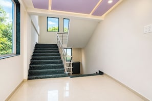 A staircase with a handrail leading to a landing with a window.