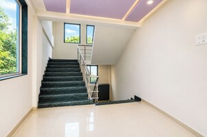 A staircase with a handrail leading to a landing with a window.