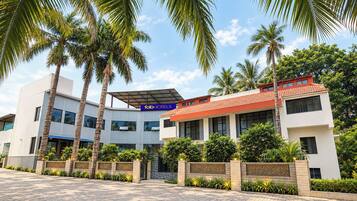A hotel with a modern design, featuring a flat roof, large windows, and a signboard.