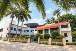 A hotel with a modern design, featuring a flat roof, large windows, and a signboard.